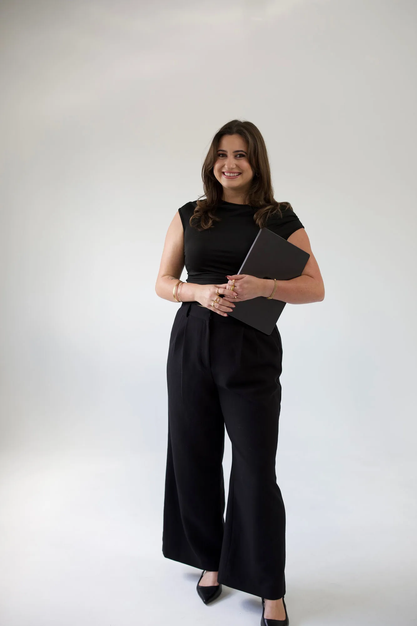 Keeley Rubal, co-founder of The Social Planner, smiling and holding a laptop